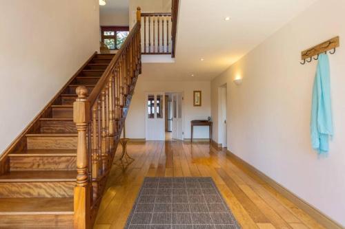 a hallway with wooden stairs and a rug at The Villa - On the Waterford Greenway Kilmacthomas in Kilmacthomas