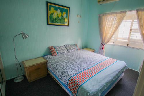 Cairns NorthにあるCairns Sunshine Lodgeのベッドルーム1室(ベッド1台、ランプ、窓付)