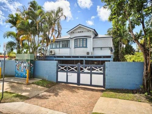 una casa blanca con una puerta y una valla en Cairns Sunshine Lodge, en Cairns North