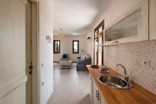 a kitchen with a sink and a living room at Kamares Villas in Kamáres