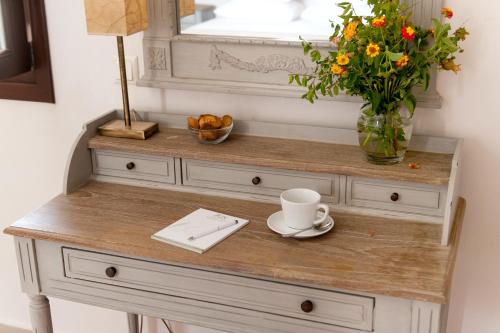 a table with a vase of flowers and a cup of coffee at Kamares Villas in Kamáres
