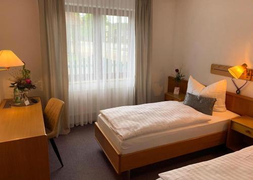 a hotel room with two beds and a window at Freigeist • Pension & Brasserie in Witzin