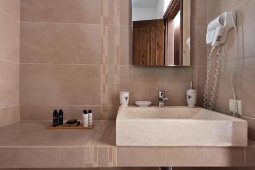 a bathroom with a white sink and a mirror at Kamares Villas in Kamáres