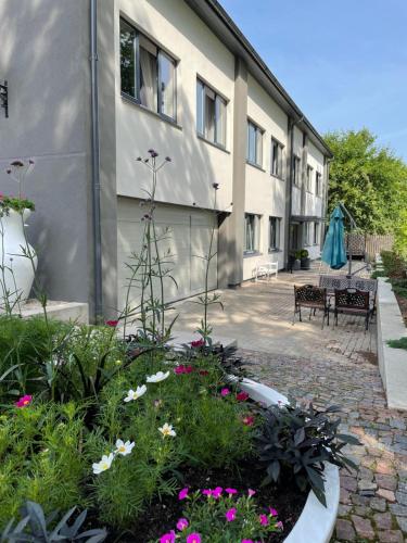 un jardin en face d'un bâtiment fleuri dans l'établissement Comfort Hotel Kuldiga, à Kuldīga