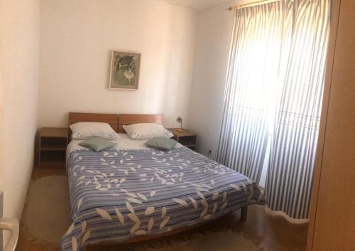 a bedroom with a bed and a large window at Elena in Benkovac