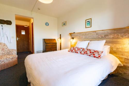 a bedroom with a large white bed with two pillows at L'Escale (accès en télécabine) in Châtel