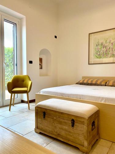 a bedroom with two beds and a yellow chair at Villa Marta- Puglia Mia apartments in Impalata