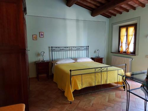 um quarto com uma cama com um cobertor amarelo em Agriturismo Il Giovannello em Roccastrada