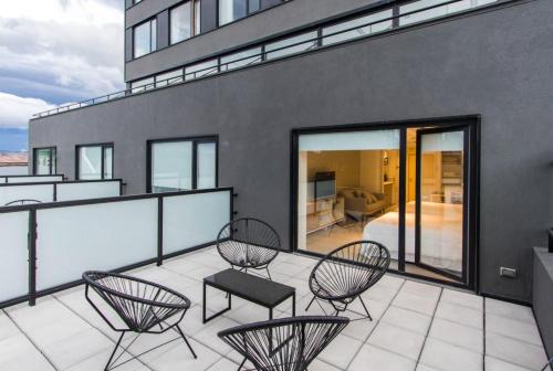 a balcony with chairs and a bed on a building at Austral Departamentos in Ushuaia