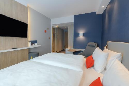a hotel room with a bed and a tv at Holiday Inn Express Göttingen by IHG in Göttingen