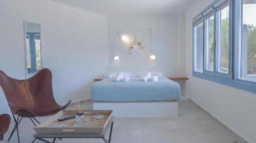 a bedroom with a bed and a table and a chair at Akasha Suite II in Vathi