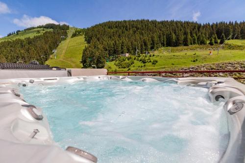 a jacuzzi tub with a view of a mountain at L'Escale (accès en télécabine) in Châtel
