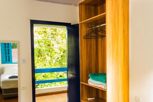 a room with a book shelf and a window at Flow Hostel Juquehy in Juquei