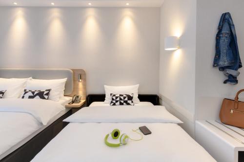 two beds in a small room with white walls at Holiday Inn Express Göttingen by IHG in Göttingen