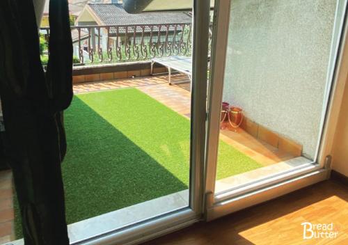 a sliding glass door with a view of a balcony with green grass at Bread & Butter in Albignasego
