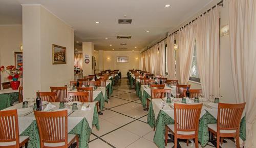 a dining room with tables and chairs in a restaurant at Hotel Villa Flores in Marina di Pietrasanta