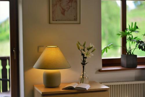 a lamp sitting on a table with a book at OVCA Apartament in Piechowice