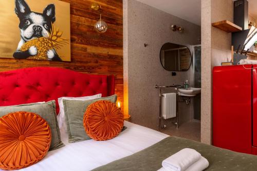 a bedroom with a bed with a red headboard at Boutique Apartment Venezia Duo in Kuldīga