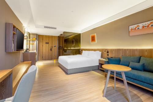 a hotel room with a bed and a couch at TRUE Go hotel in Chengdu