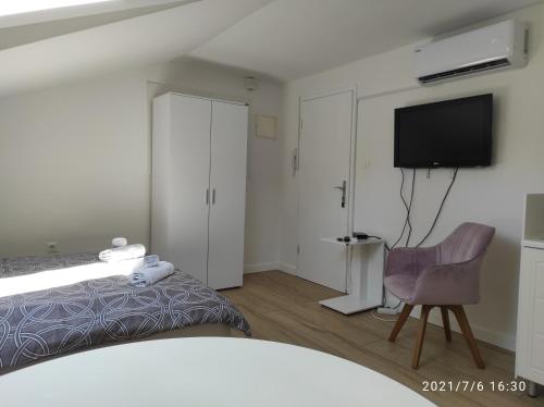 una camera con letto, TV e sedia di Studio apartman Marko a Opatija