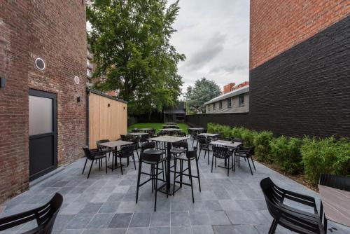 eine Terrasse mit Tischen und Stühlen im Innenhof in der Unterkunft Vinotel X in Tongeren