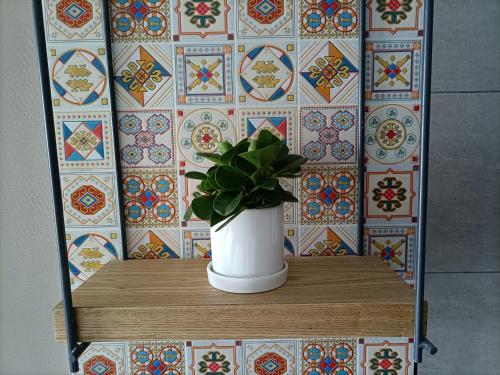 a plant in a white vase sitting on a table at TRUE Go hotel in Chengdu