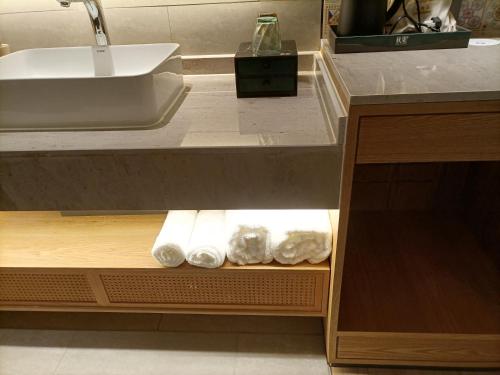 a bathroom with a sink and towels in a drawer at TRUE Go hotel in Chengdu