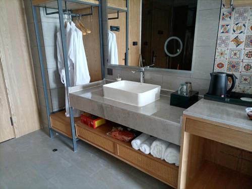 a bathroom with a sink and a mirror and towels at TRUE Go hotel in Chengdu