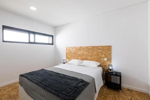 Un dormitorio con una cama grande y una ventana en As Casas da Margarida en Ribeira Grande