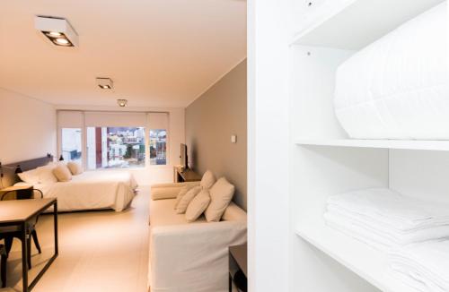 a hotel room with two beds and a dining room at Austral Departamentos in Ushuaia