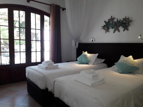 two beds in a hotel room with towels on them at Monte-Bougainvillea in Faro