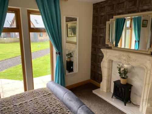 a bedroom with a fireplace and a mirror at Balmaha Lodges and Apartments in Balmaha
