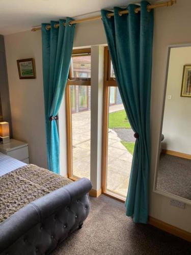 a bedroom with a bed and a sliding glass door at Balmaha Lodges and Apartments in Balmaha