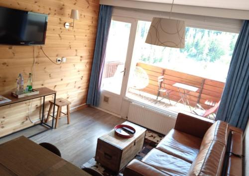 ein Wohnzimmer mit einem Sofa und einem großen Fenster in der Unterkunft Pra-Loup 1600, Front de Neige in Pra-Loup