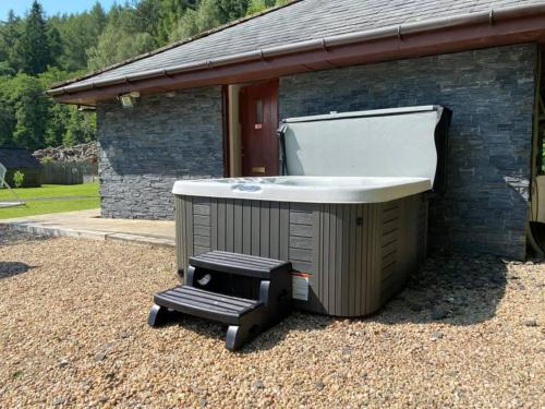 a hot tub sitting next to a building at Balmaha Lodges and Apartments in Balmaha