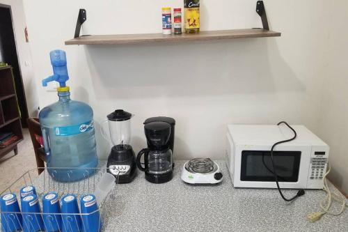 a microwave and a bottle of water next to a blender at Casa completa en pleno centro de Ciudad Valles in Ciudad Valles
