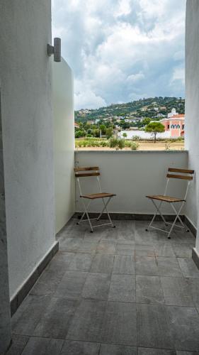a balcony with chairs and a view of a city at Pepi B&B in Santa Maria di Castellabate