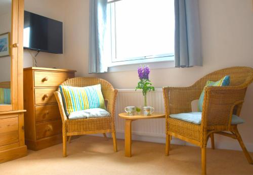 セント・アンドルーズにあるNo12 Bed and Breakfast, St Andrewsの椅子2脚、テーブル、窓が備わる客室です。