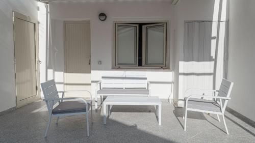 two chairs and a table and a bench on a building at Pepi B&B in Santa Maria di Castellabate