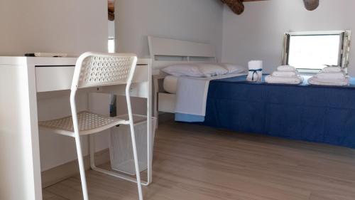 a room with a desk and a bed with a chair at Pepi B&B in Santa Maria di Castellabate