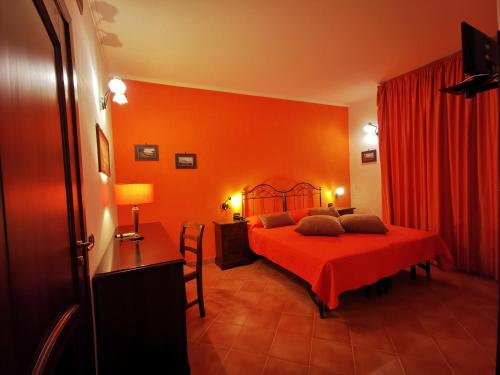 a bedroom with a bed with an orange wall at Hotel Neapolis in Naples