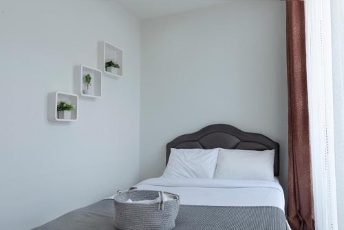 a bedroom with a bed with a black headboard and a basket at Mee Hug Guesthouse in Phayao