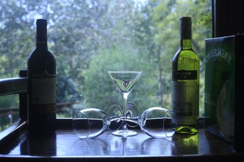 a table with glasses and two bottles of wine at LUSHOTO EXECUTIVE LODGE in Lushoto