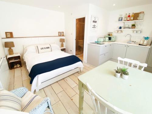 um pequeno quarto com uma cama e uma cozinha em The Hideout em Chichester