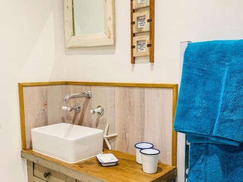 ein Badezimmer mit einem Waschbecken und einem blauen Handtuch in der Unterkunft The Hideout in Chichester