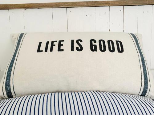 a pillow with the words life is good on a bed at The Hideout in Chichester