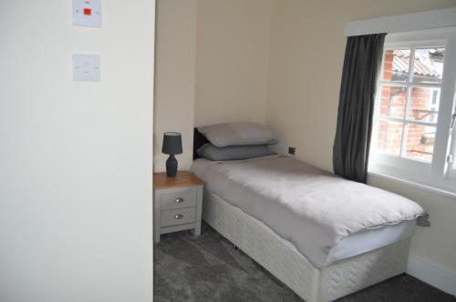 a small bedroom with a bed and a window at The Rose & Crown in Bulford