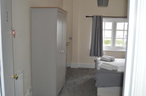 a small bedroom with a bed and a window at The Rose & Crown in Bulford
