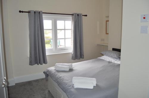 a bedroom with a bed with two towels on it at The Rose & Crown in Bulford