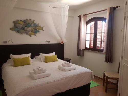 a bedroom with a bed with two towels on it at Monte-Bougainvillea in Faro